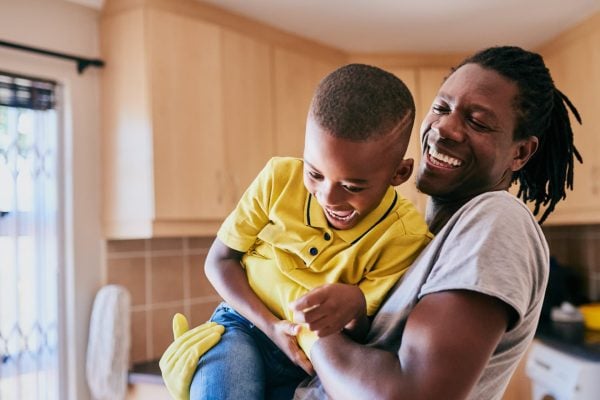 Cropped shot of an affectionate young single father playing with his son while cleaning in their kitchen at home